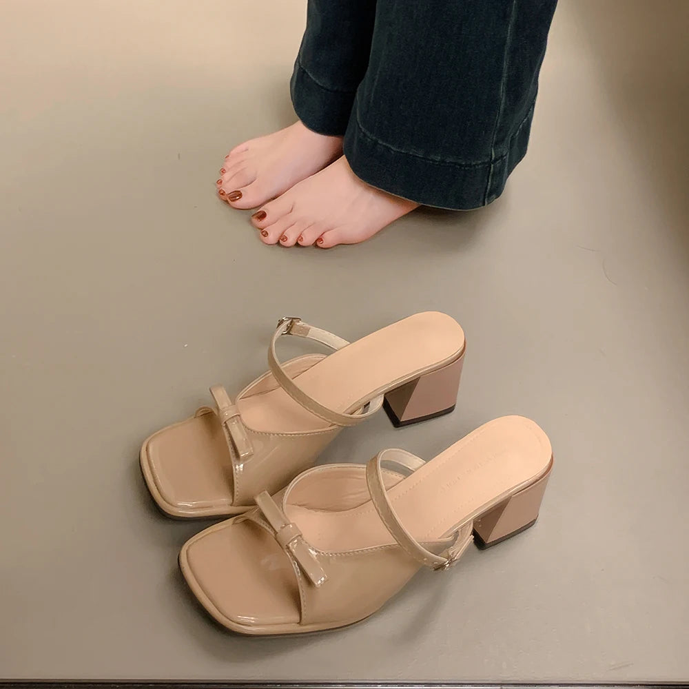 Sandalias de tacón color rosa nude con detalle de lazo mariposa. Diseño elegante y cómodo, perfectas para mujer en verano u ocasiones especiales.